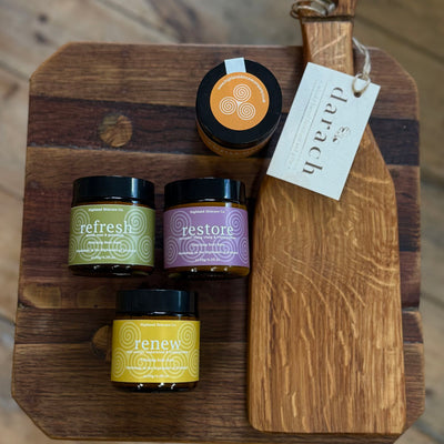 Four jars labeled 'refresh', 'restore', and 'renew' on a wooden board with a 'Darach' tag.