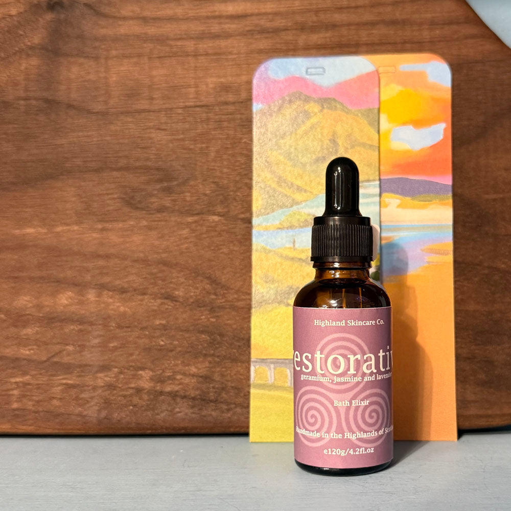 Bottle of 'Restore' skincare product with a colorful card in the background on a wooden surface.