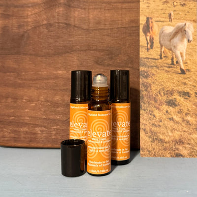 Three bottles of 'elevate' skincare product with a wooden background and horse image.